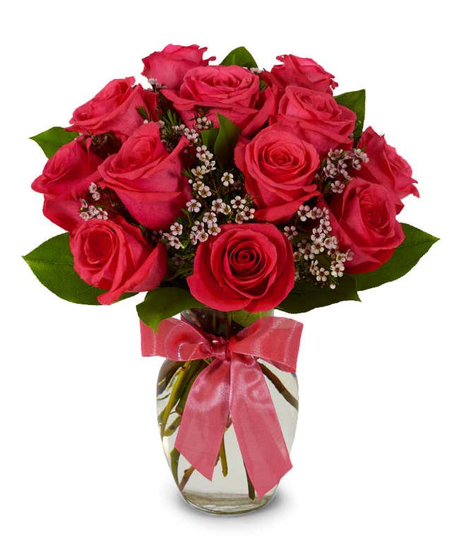 Hot pink long stemmed roses in a clear glass vase